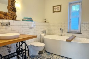 Bad mit Wanne an Schlafzimmer 1